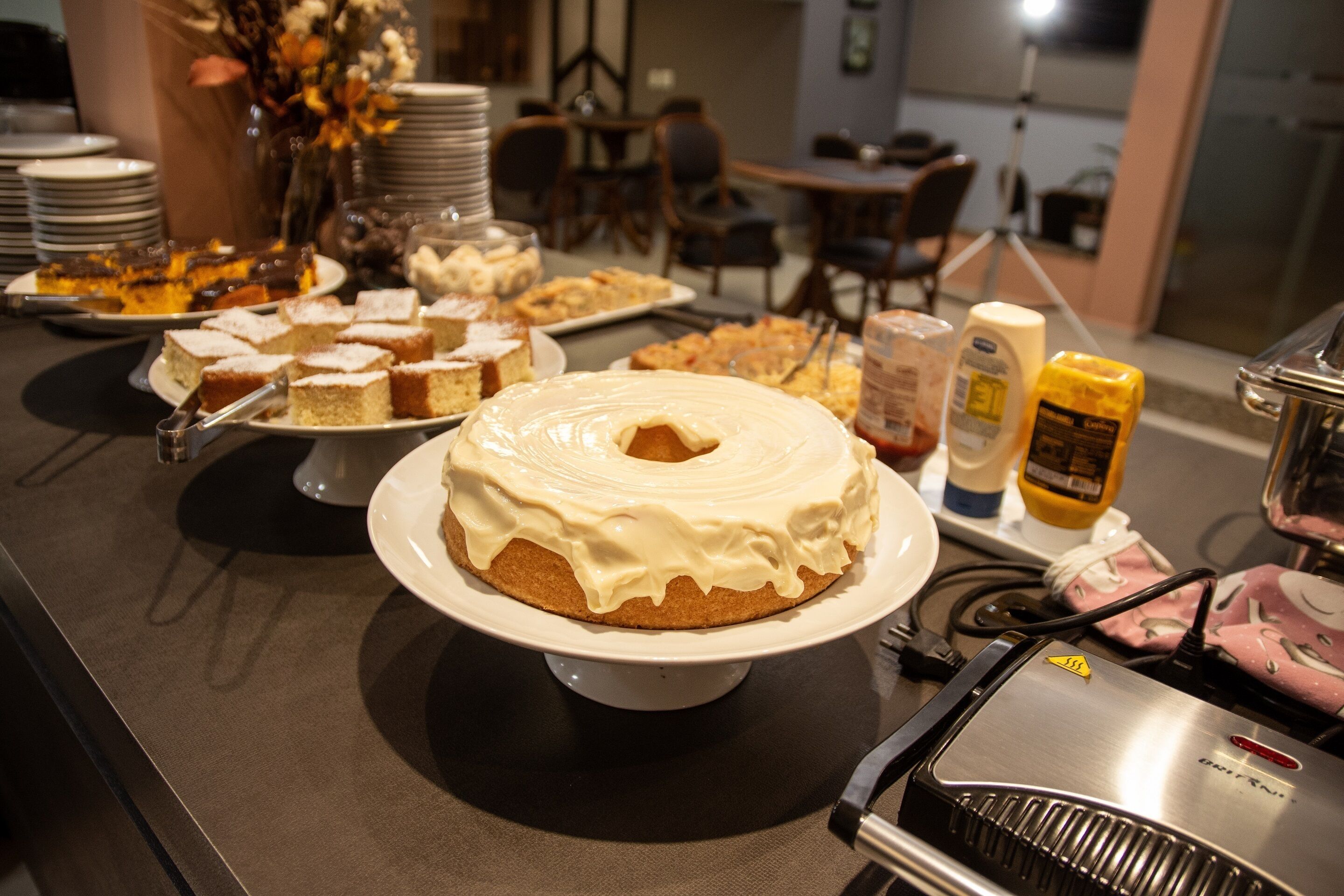 A buffet table with various desserts and food items.