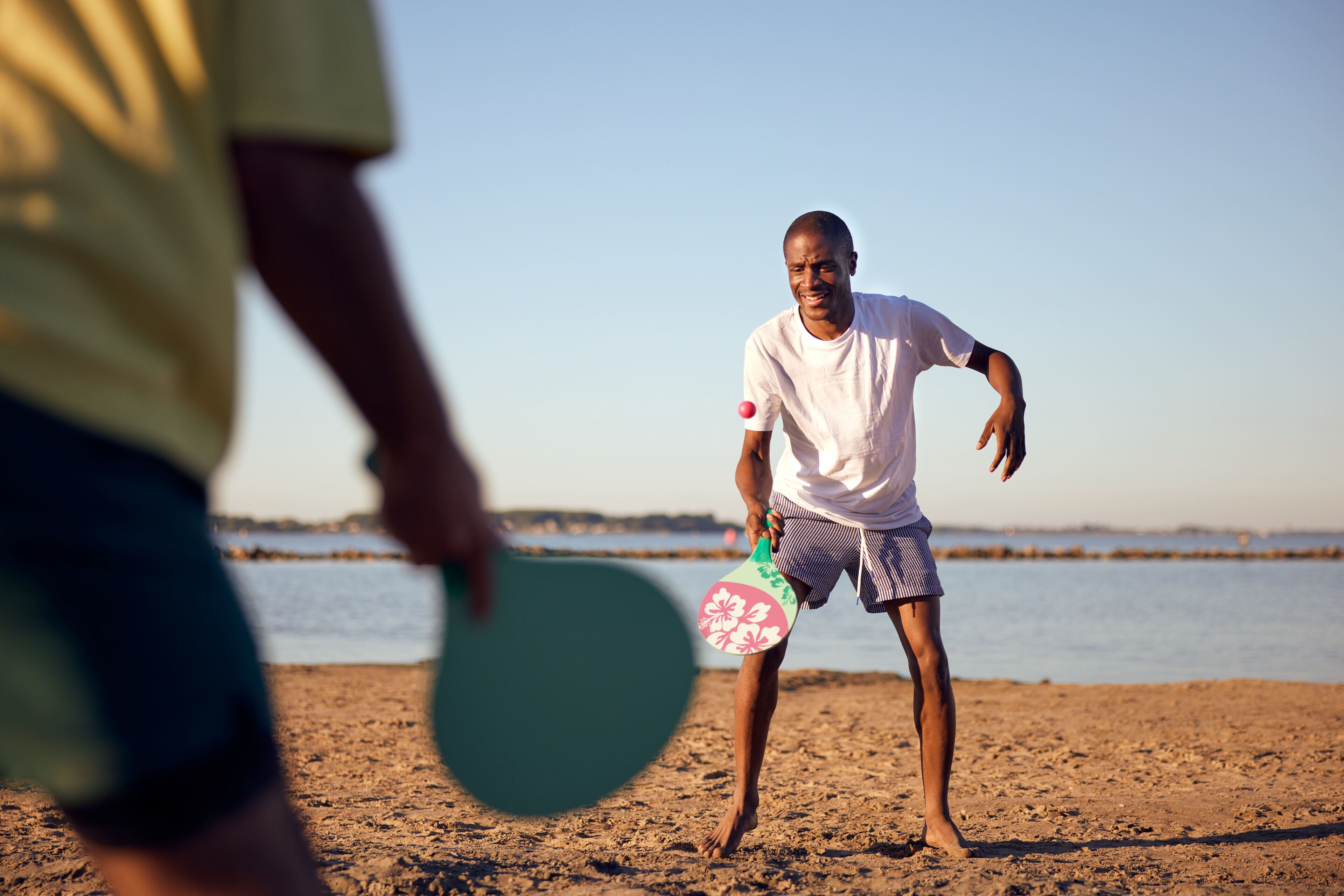 Eine Strandansicht mit einer Person, die einen Frisbee hält.