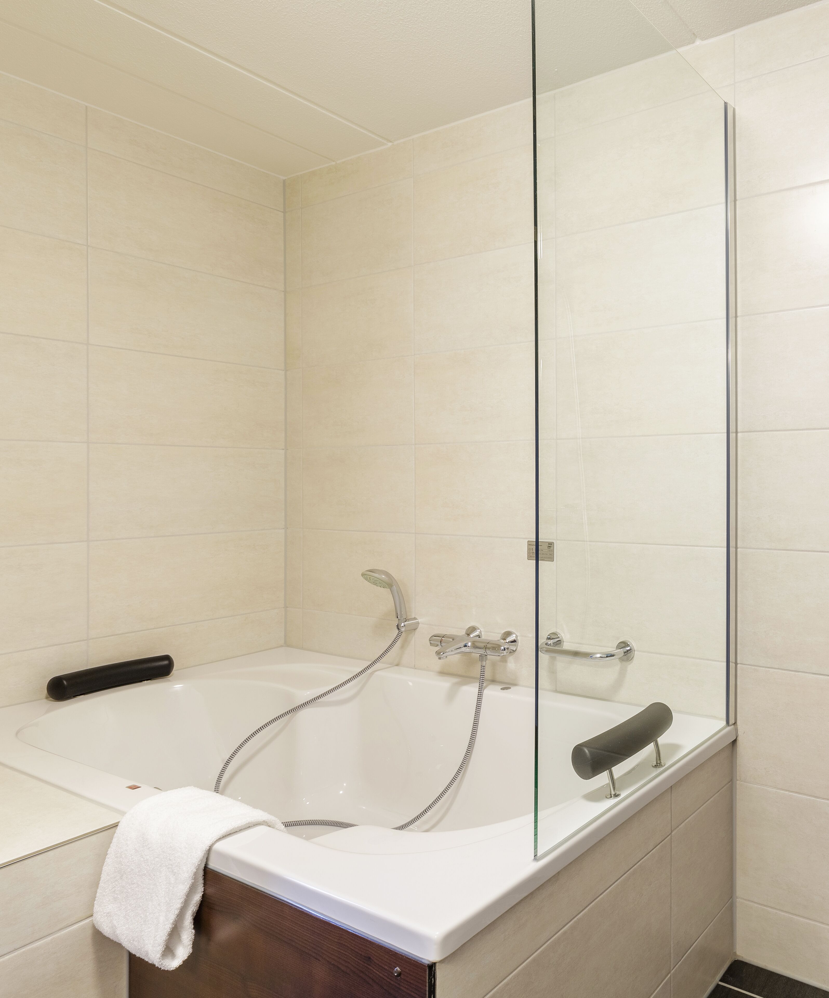 A bathroom with a bathtub, a shower, and a glass-enclosed shower area.