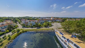 A riverside town with a boat dock, buildings, and greenery. - Center Parcs Port Zélande (Ouddorp)