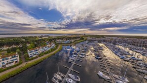 A marina with numerous boats docked, surrounded by residential buildings and greenery. - Center Parcs Port Zélande (Ouddorp)