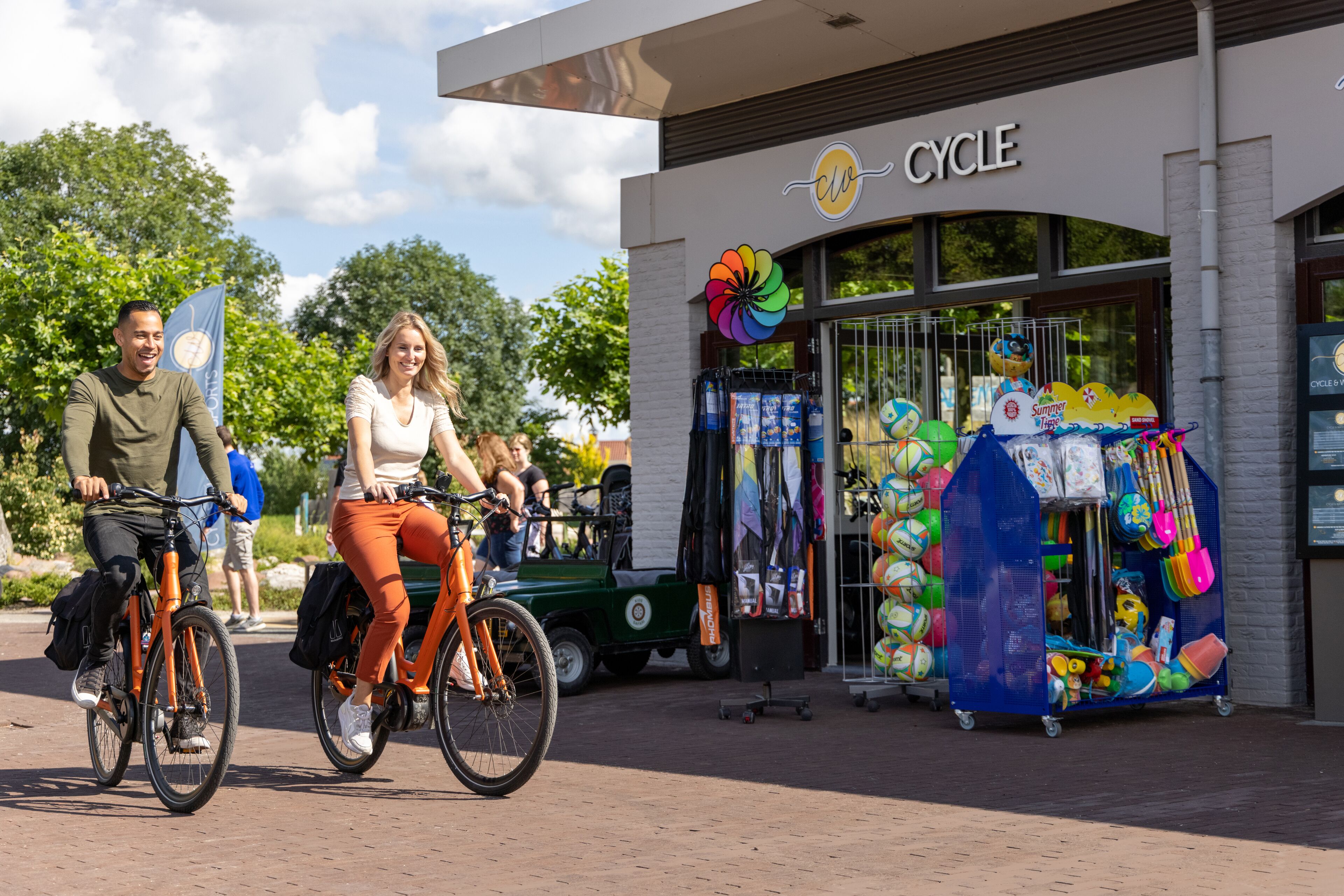 A storefront with a sign reading "CYCLE" and a display of colorful children's toys.