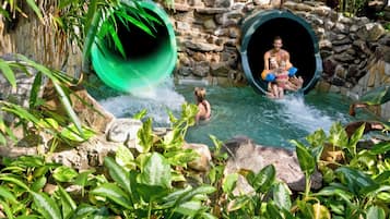 Slide into fun in this lush, natural setting, featuring a large circular opening and a pool area.