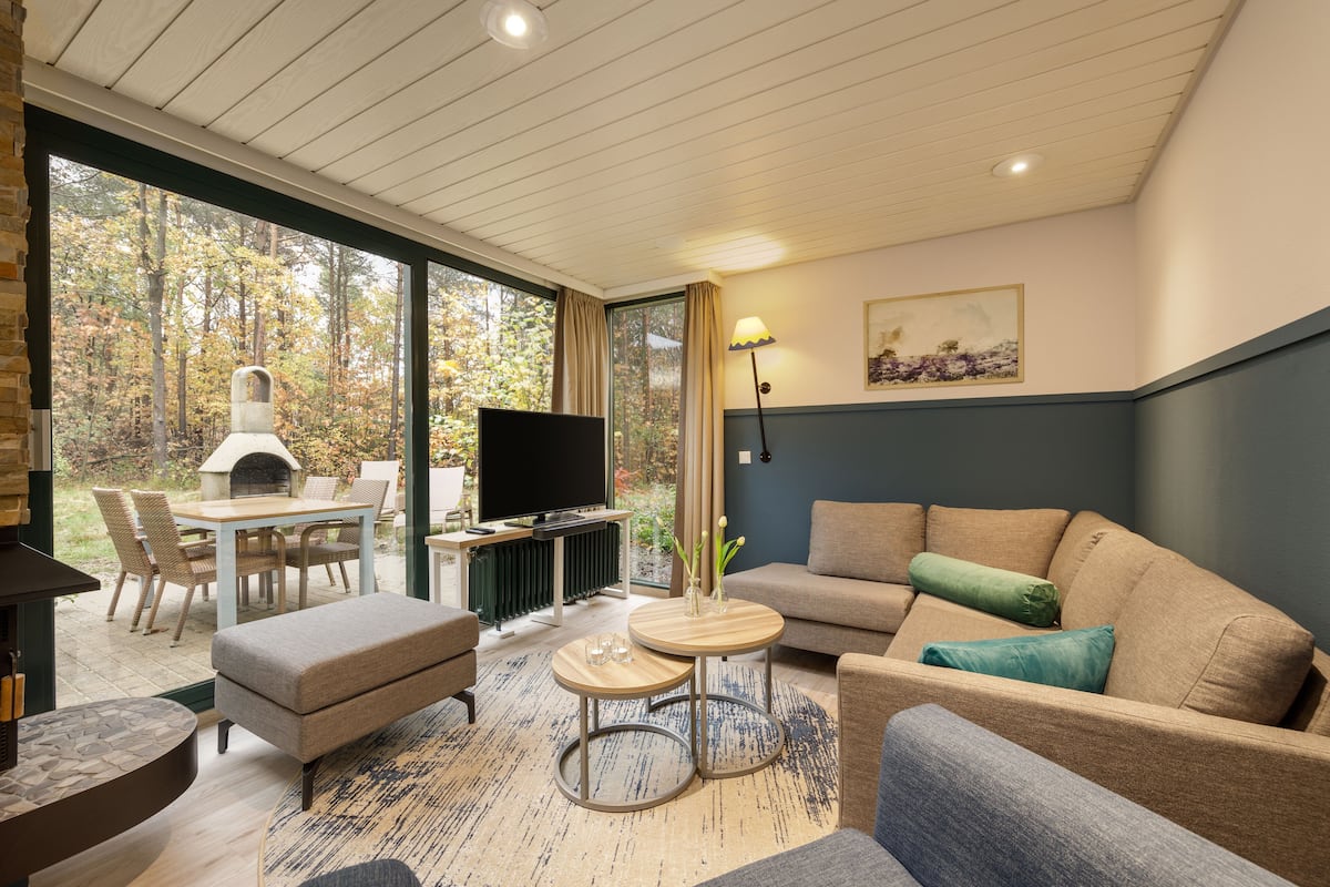 En moderne stue med pejs, fjernsyn, sofa og spiseplads med bord og stole.