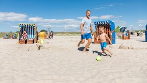 En strandscen med människor och strandhytter.