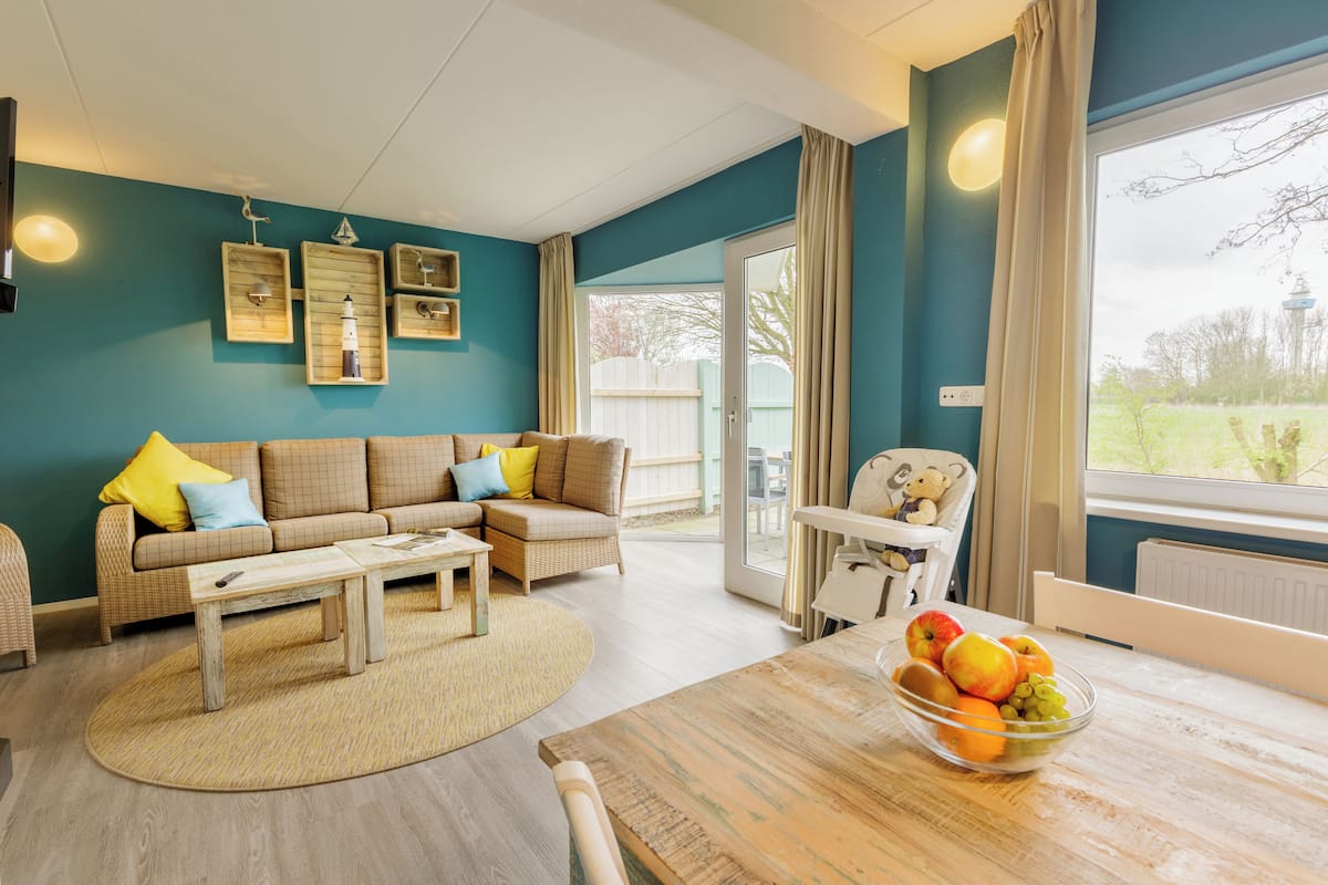 A cozy living room with a sofa, coffee table, and a bowl of fruit on a wooden table.