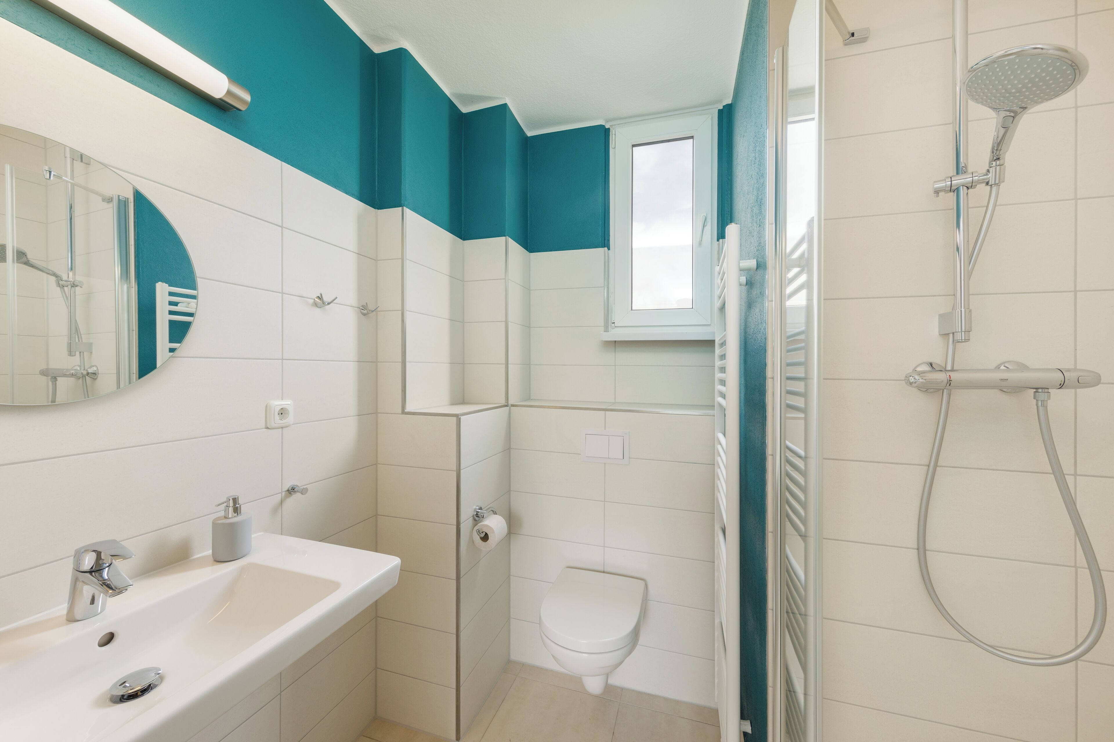 Une salle de bain moderne équipée d’une douche, de toilettes et d’un lavabo.