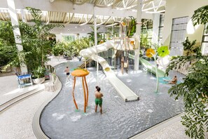 Parque acuático interior con toboganes y atracciones acuáticas.