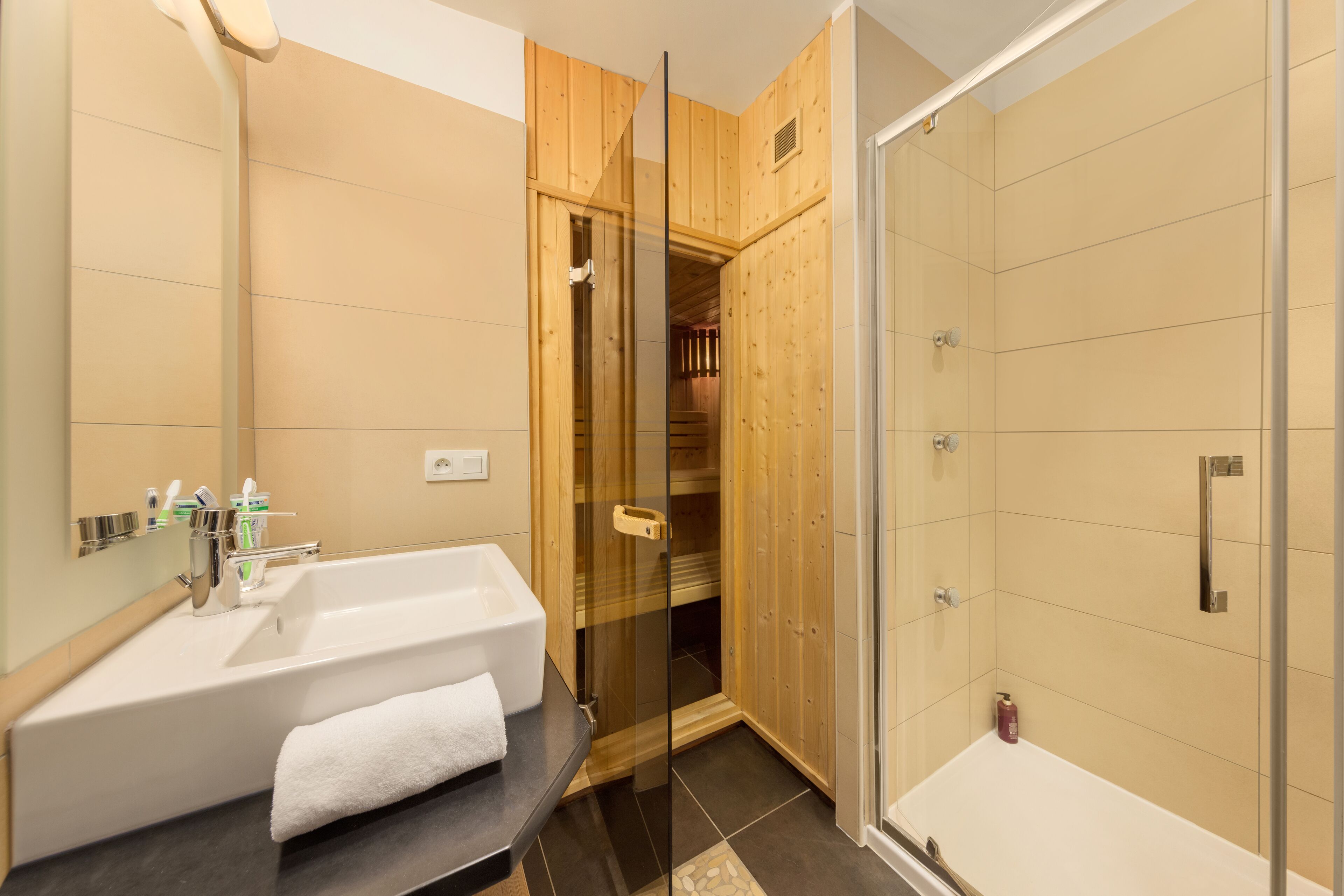 Ein modernes Badezimmer mit einer Glaskabine zur Dusche, einer weißen Badewanne und einem Holzbadezimmer-Möbel.