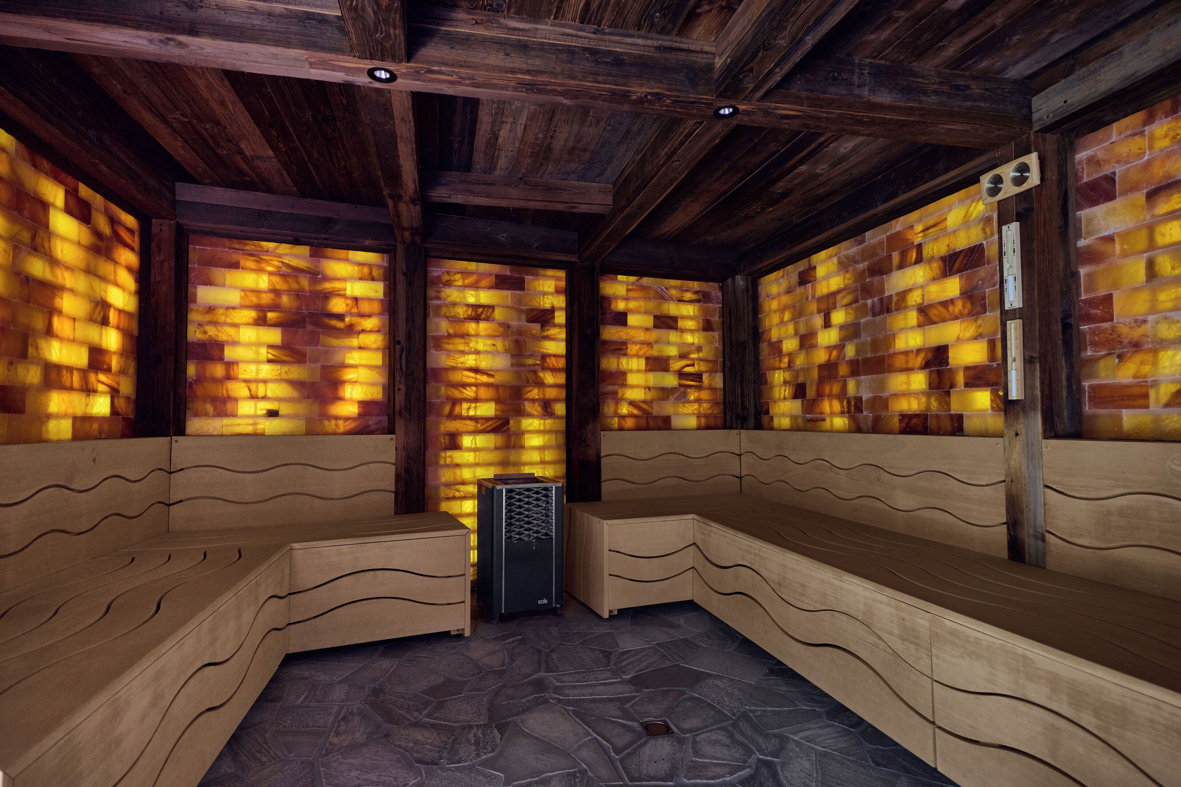 A sauna with wooden benches and a stone floor.