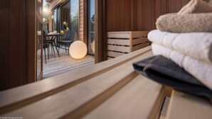 A wooden bench with towels, a table with chairs, and a glass door leading to an outdoor area with a table and chairs. - Center Parcs Les Trois Forêts (Fraquelfing)