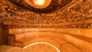 A curved wooden bench seating area with a patterned ceiling and a circular skylight. - Center Parcs Les Trois Forêts (Fraquelfing)