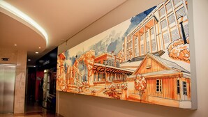 Un pasillo con un gran mural de edificios y árboles.
