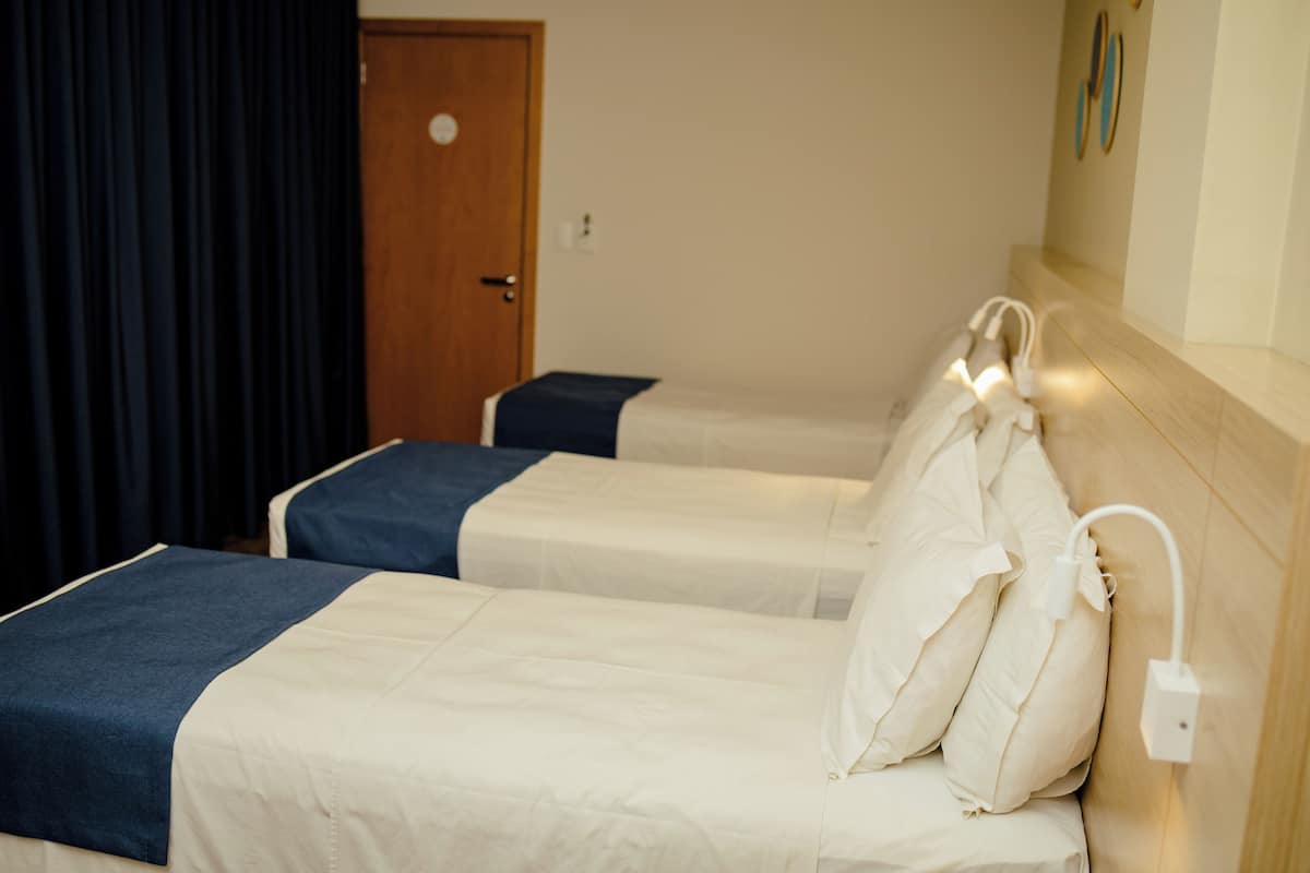 Driepersoonskamer, 3 eenpersoonsbedden, uitzicht op stad | Hypoallergeen beddengoed, een minibar, een bureau