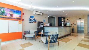 Un moderno mostrador de recepción de hotel, con asientos y una pantalla grande que muestra una vista panorámica.