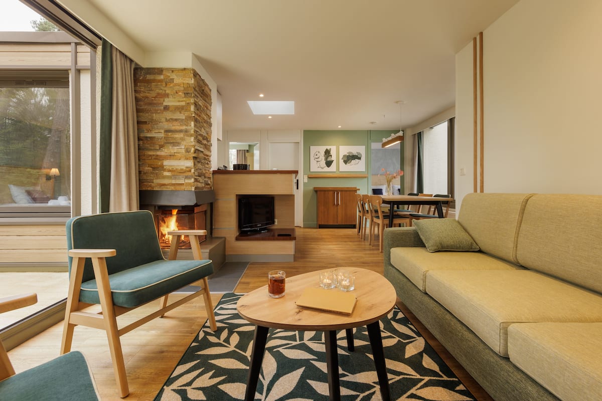 Una sala de estar moderna con chimenea, un sofá, una mesa de centro y un comedor.