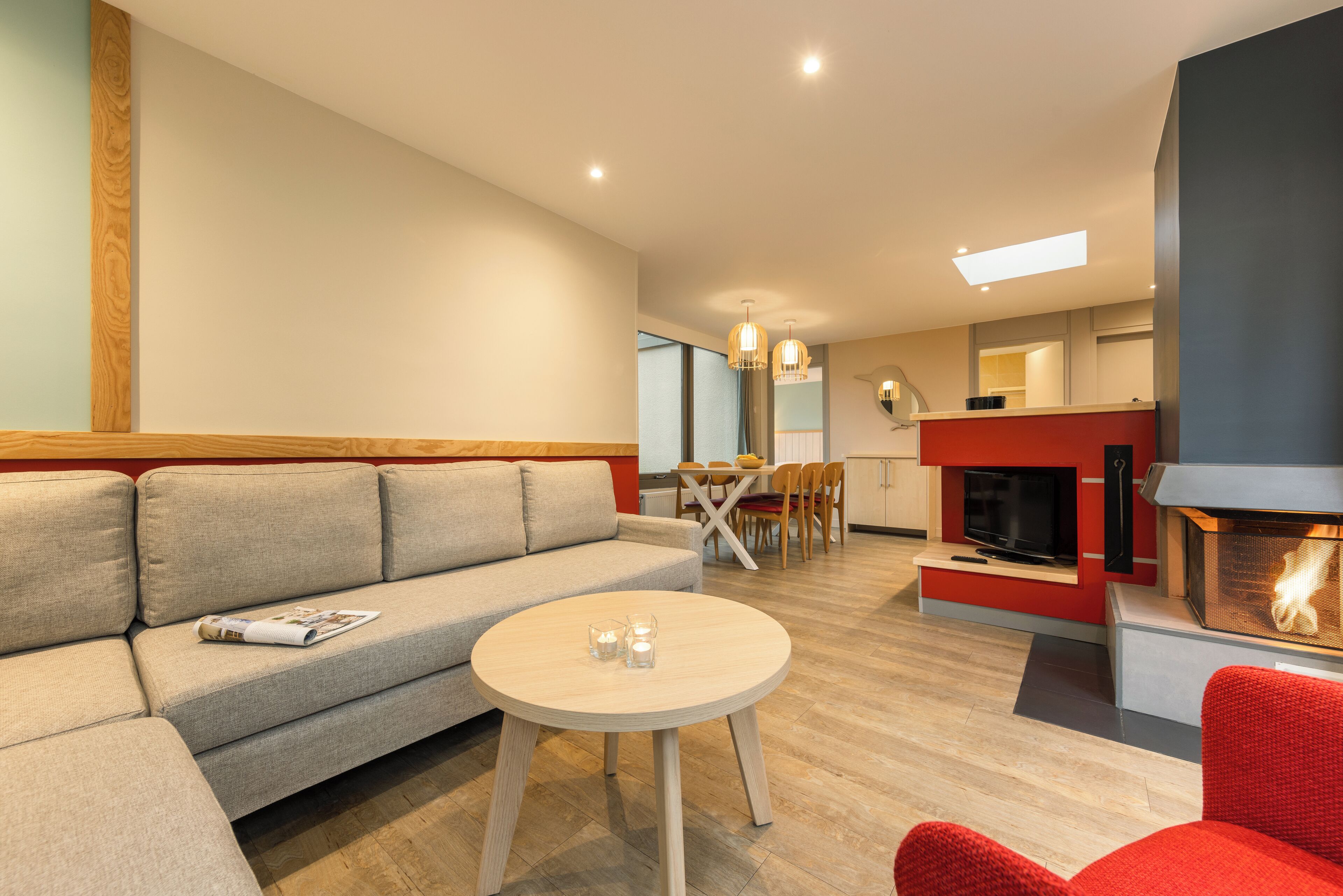 Una sala de estar moderna con sofá, una mesita redonda y una chimenea.