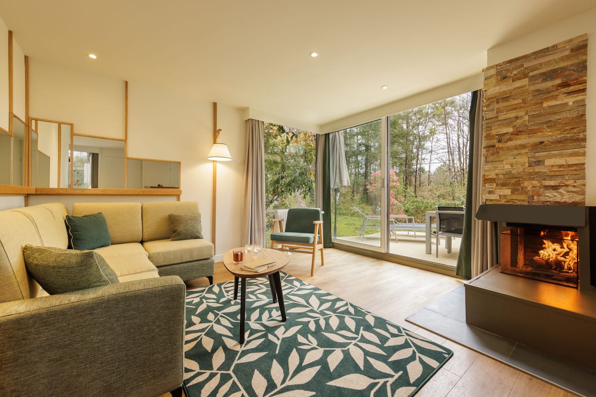 Una sala moderna con sofá, mesa de centro y chimenea.