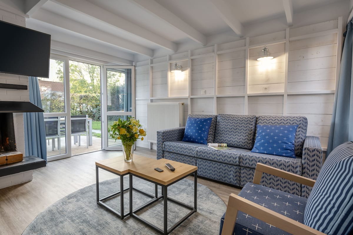 Un salon moderne avec un canapé, une table basse et une cheminée.