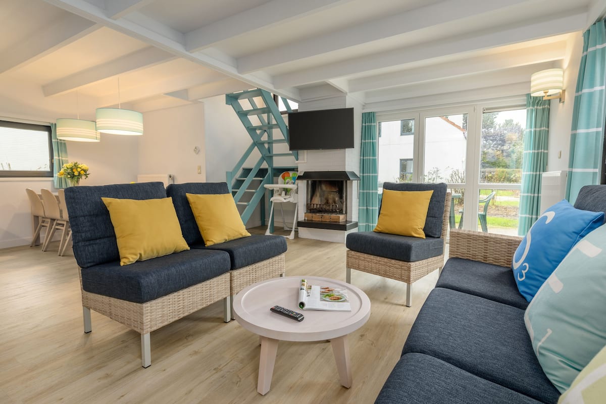 Un salon moderne avec un ensemble de canapés, une table basse et une cheminée.