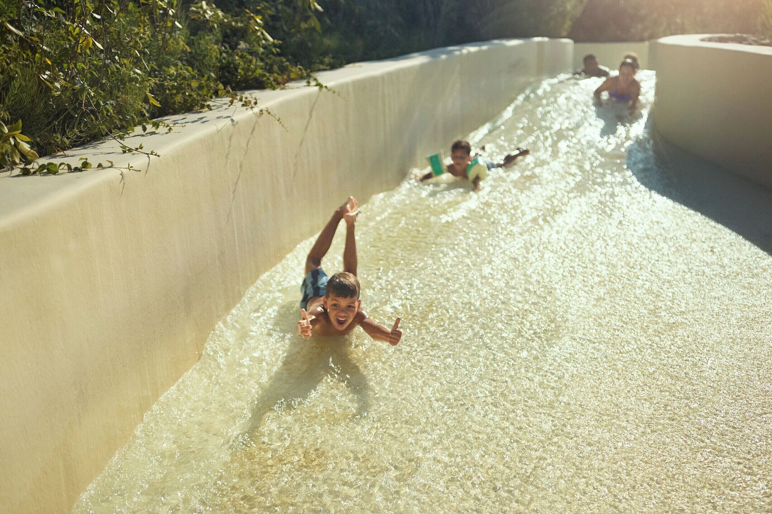A water slide with people sliding down.