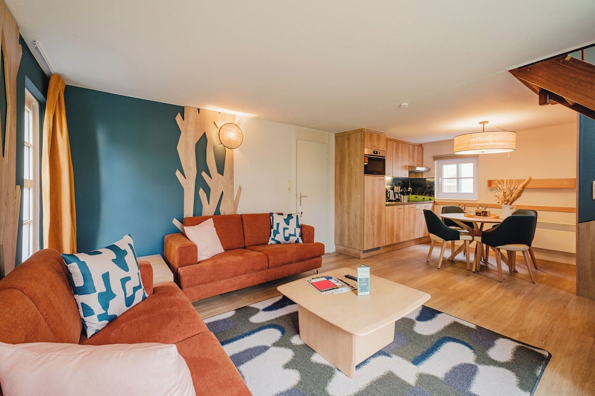 Un salon moderne avec un canapé, une table basse et un coin repas.