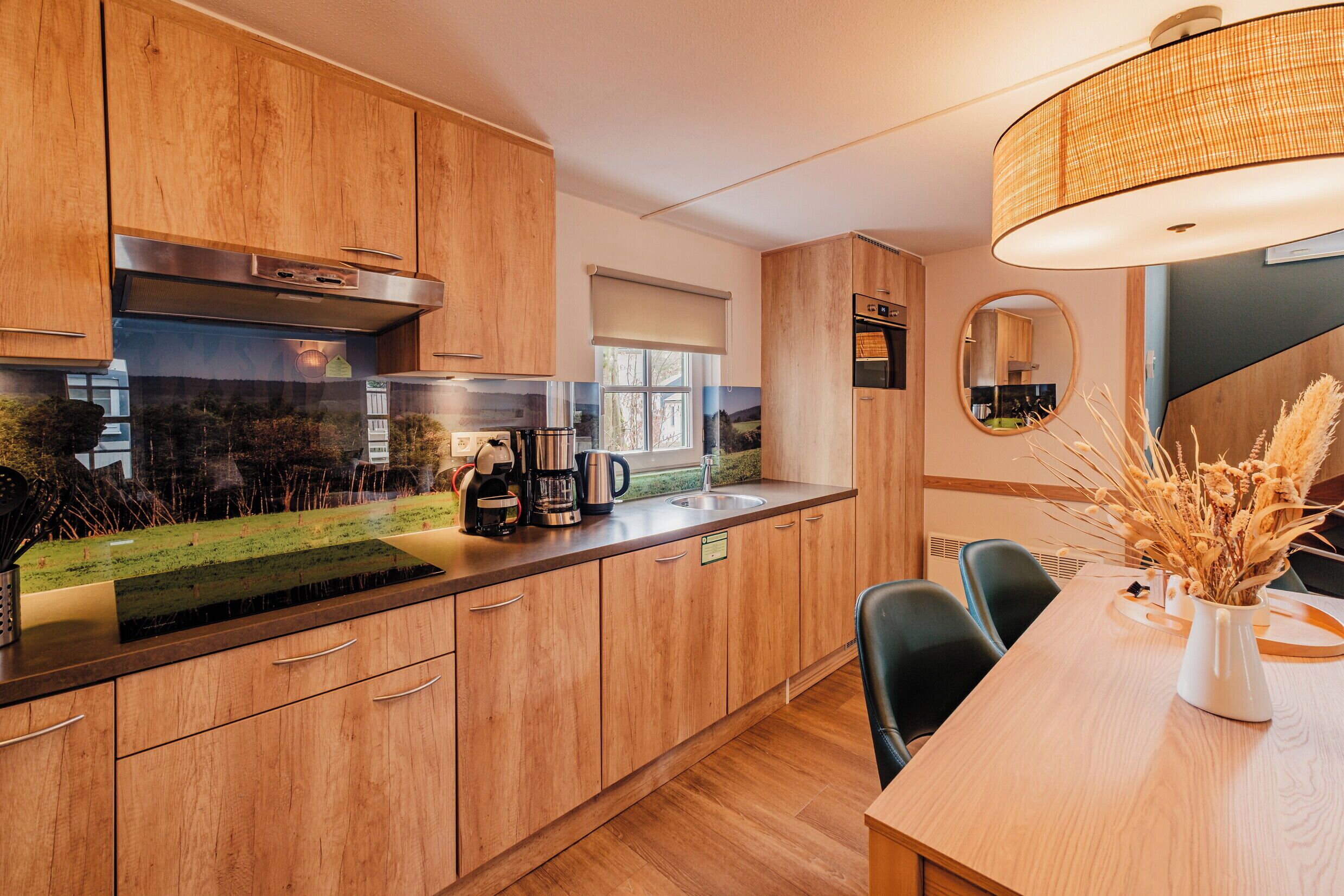 Eine moderne Küche mit Holzsärchen, einem eingebauten Herd und einem Essbereich mit Tisch und Stühlen.