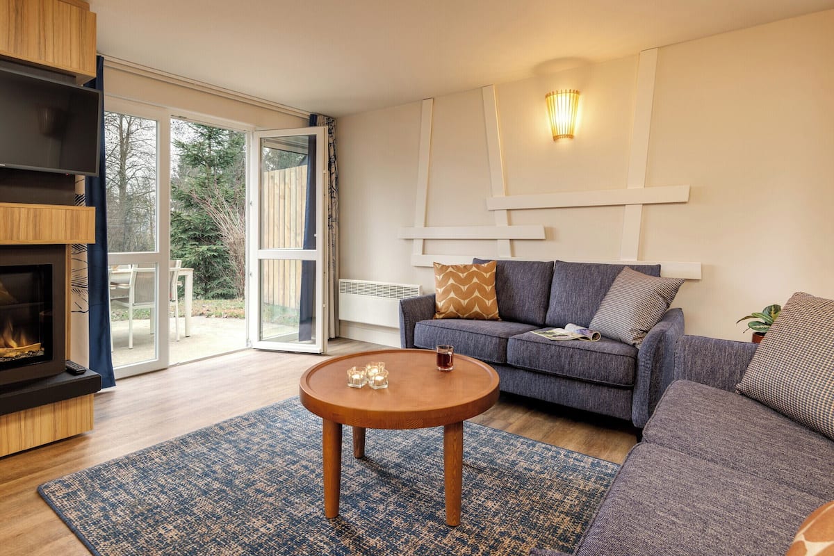 Un salon moderne avec un canapé, une table basse et une cheminée.