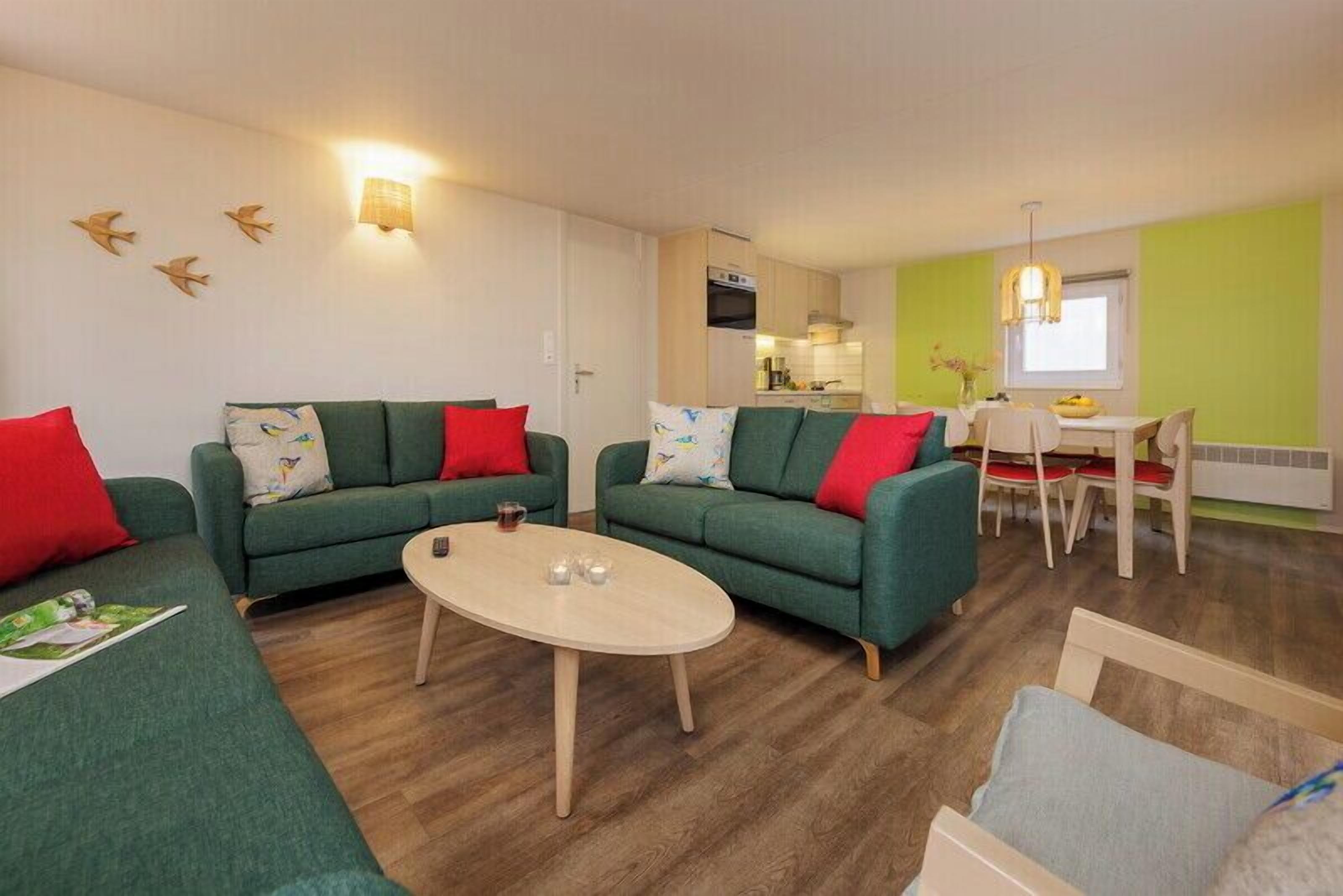 Een moderne woonkamer met twee banken, een salontafel en een eethoek met een tafel en stoelen.