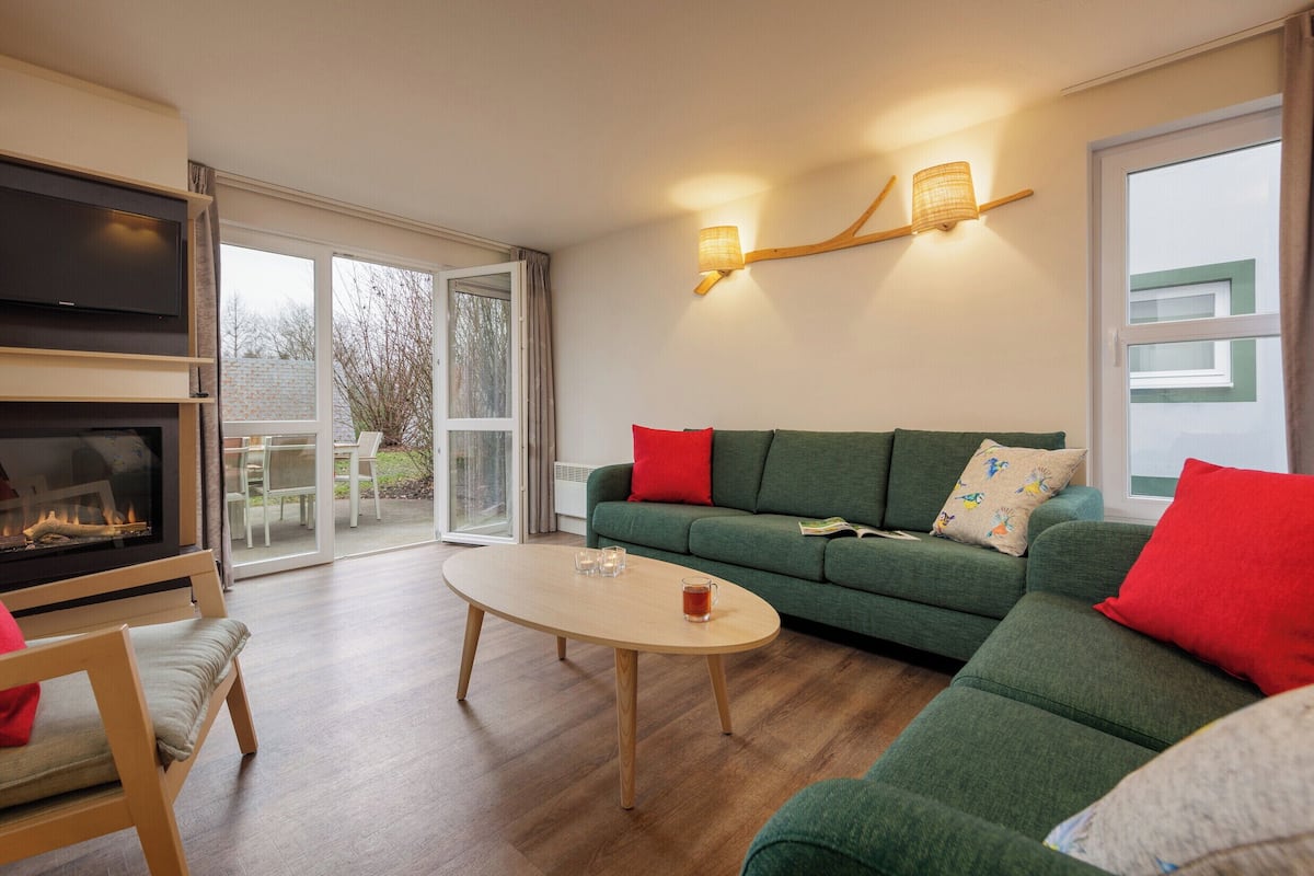 Un salon moderne avec un canapé, une table basse et une cheminée.
