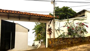 A residential area with a white house, a stone wall, and a tiled roof.