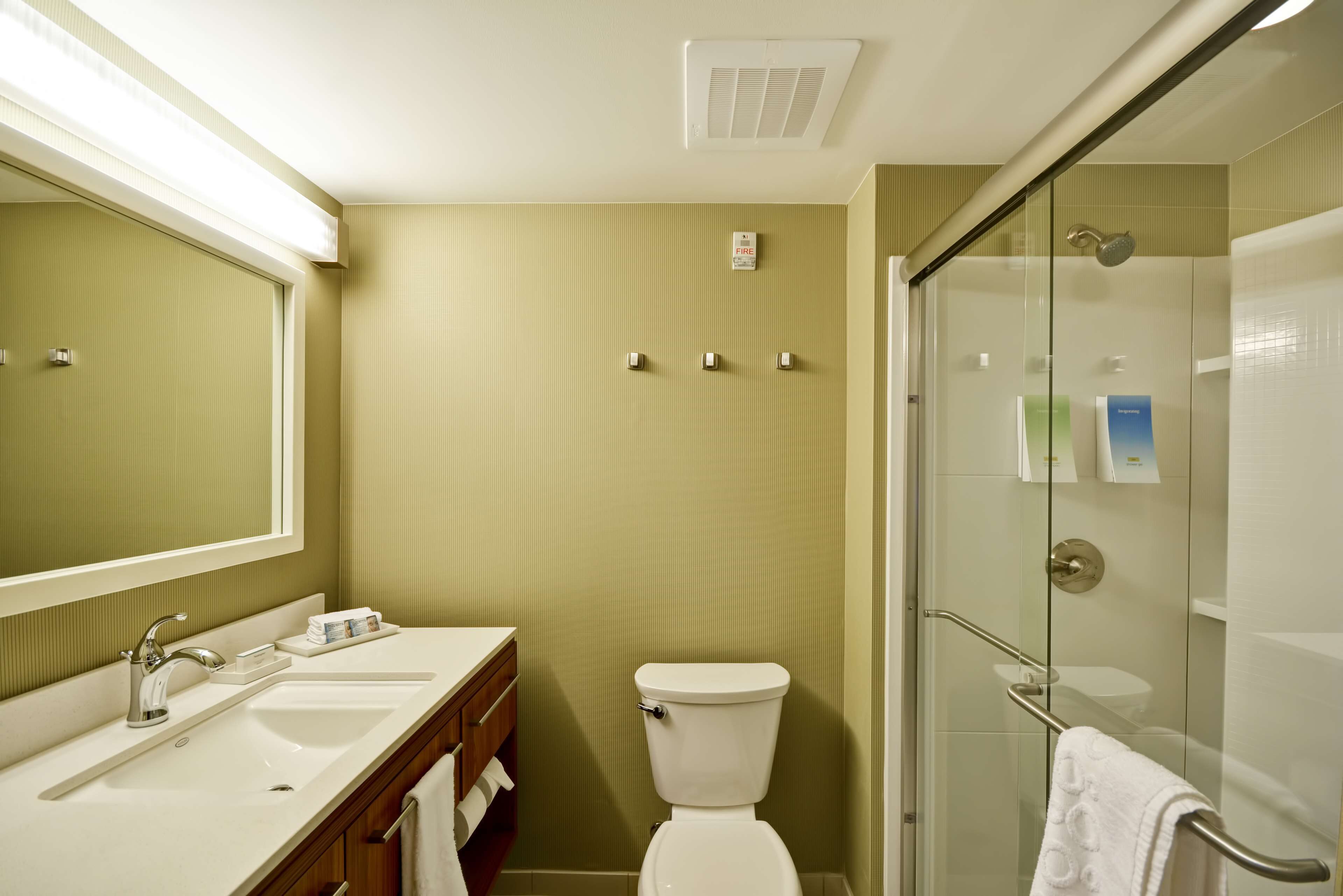 A bathroom with a sink, toilet, and glass-enclosed shower.