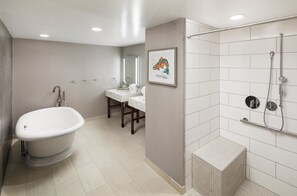 A modern bathroom with a freestanding bathtub, a shower area, and a vanity with a mirror. - DoubleTree by Hilton Greeley at Lincoln Park (Greeley)