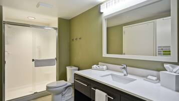 Un baño moderno con ducha, inodoro, lavamanos y tocador.