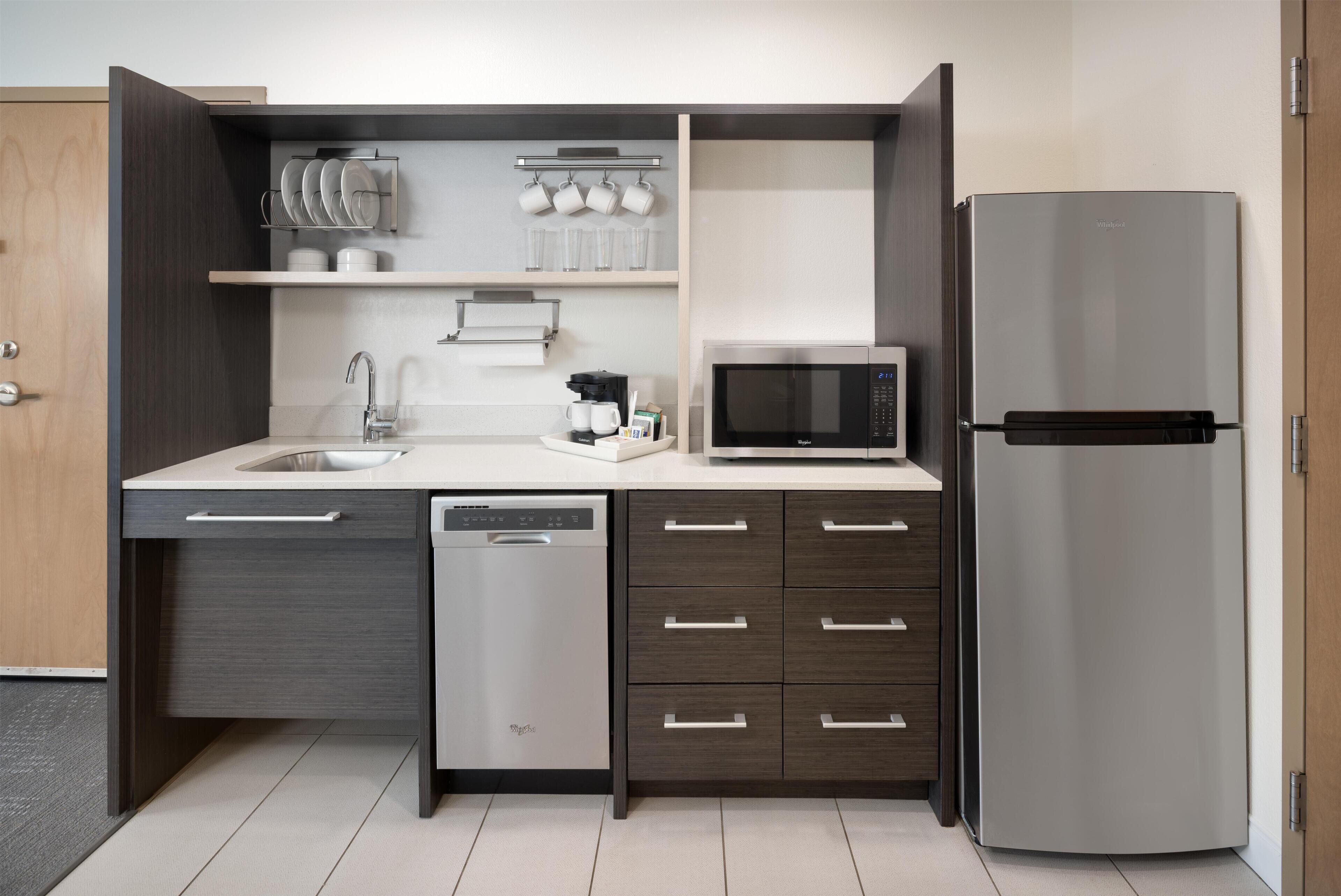 Cocina moderna equipada con lavavajillas, microondas y refrigerador de acero inoxidable.