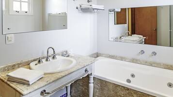 Un baño con lavabo, espejo y bañera.