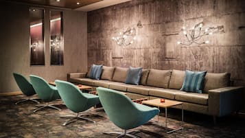 A lounge area with a sofa, chairs, and a patterned carpet.