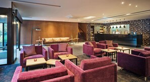 Relax in our inviting lobby, featuring plush seating, a flat-screen TV, and a reception desk.