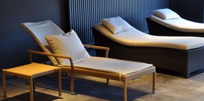 Relax in comfort with two lounge chairs against a wall of vertical slats.