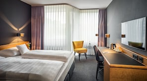 A hotel room with two beds, a desk, a chair, a large mirror, and a view of the outdoors through sheer curtains. - Best Western Hotel Kaiserslautern (Kaiserslautern)