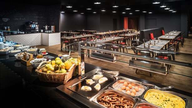 A buffet area with various food options, including eggs, sausages, and fruits. - Best Western Hotel Kaiserslautern (Kaiserslautern)