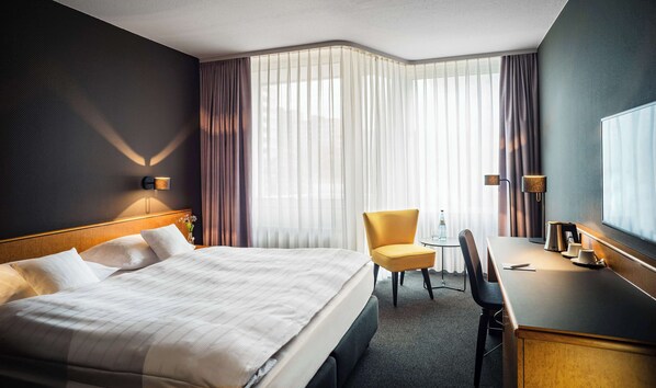 A hotel room with a large bed, a desk, a chair, and a small table. - Best Western Hotel Kaiserslautern (Kaiserslautern)