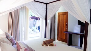A hotel room with a bed, curtains, a wooden door, and a small table. - Villa Bau Nyale (Kuta)