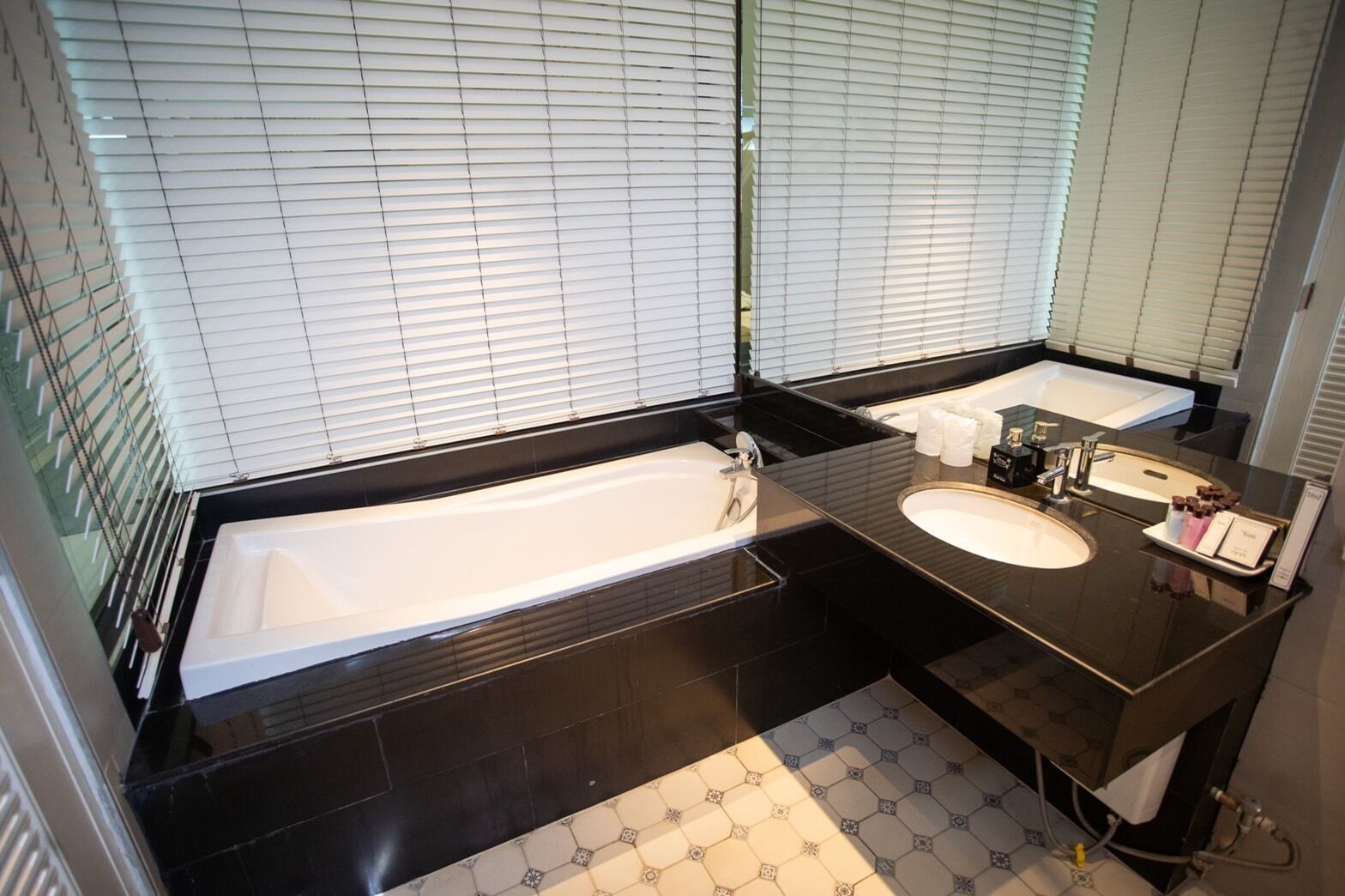 Un baño moderno con dos lavabos, una bañera grande y un tocador con espejo.