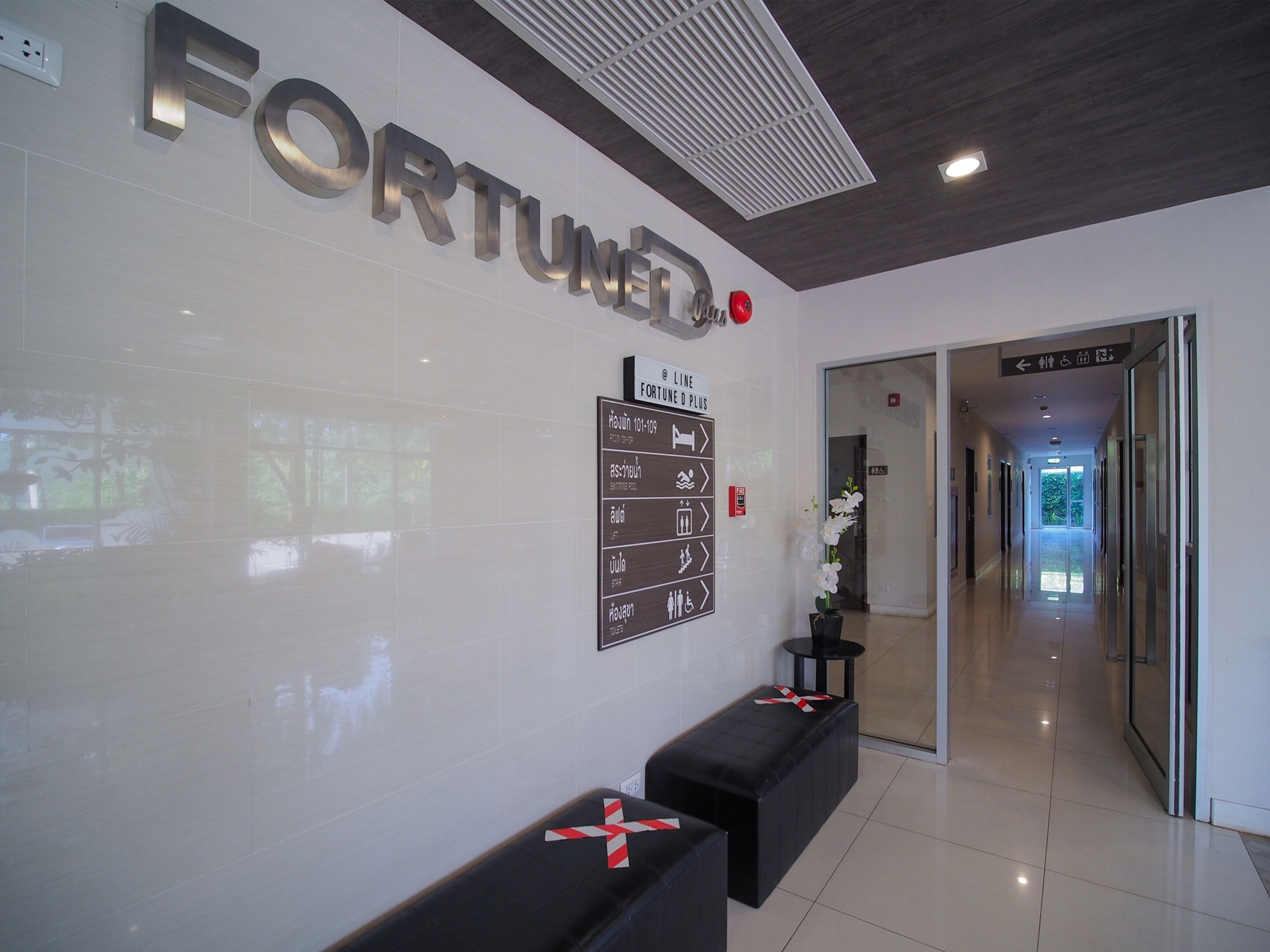 A reception area with a 'FORTUNE' sign, directional signs, and a hallway leading to other parts of the building.
