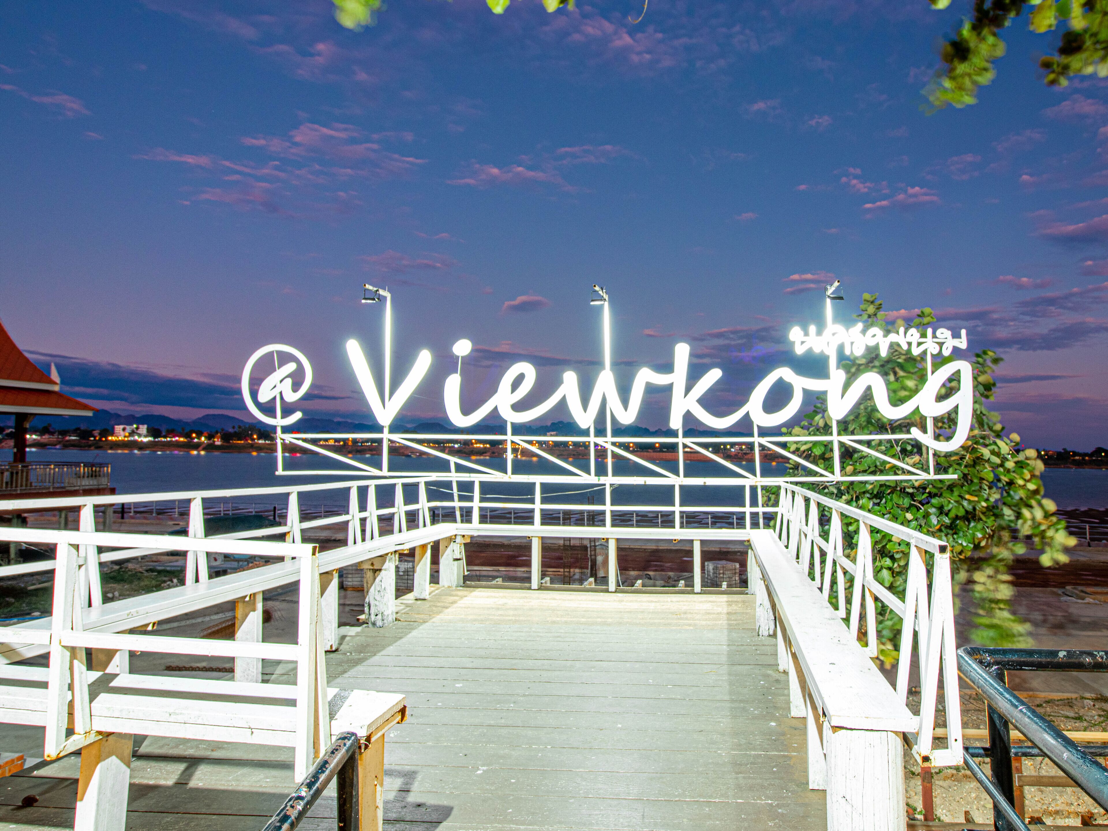 A wooden boardwalk leading to a sign with the text "@viewkong".