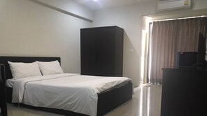 A hotel room with a bed, a desk, and a wardrobe.