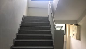 A staircase with a handrail leading to an elevator.