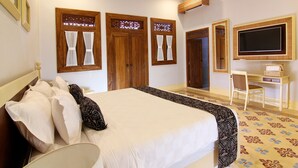 Ein Hotelzimmer mit Bett, Schreibtisch, Stuhl und Fernseher.