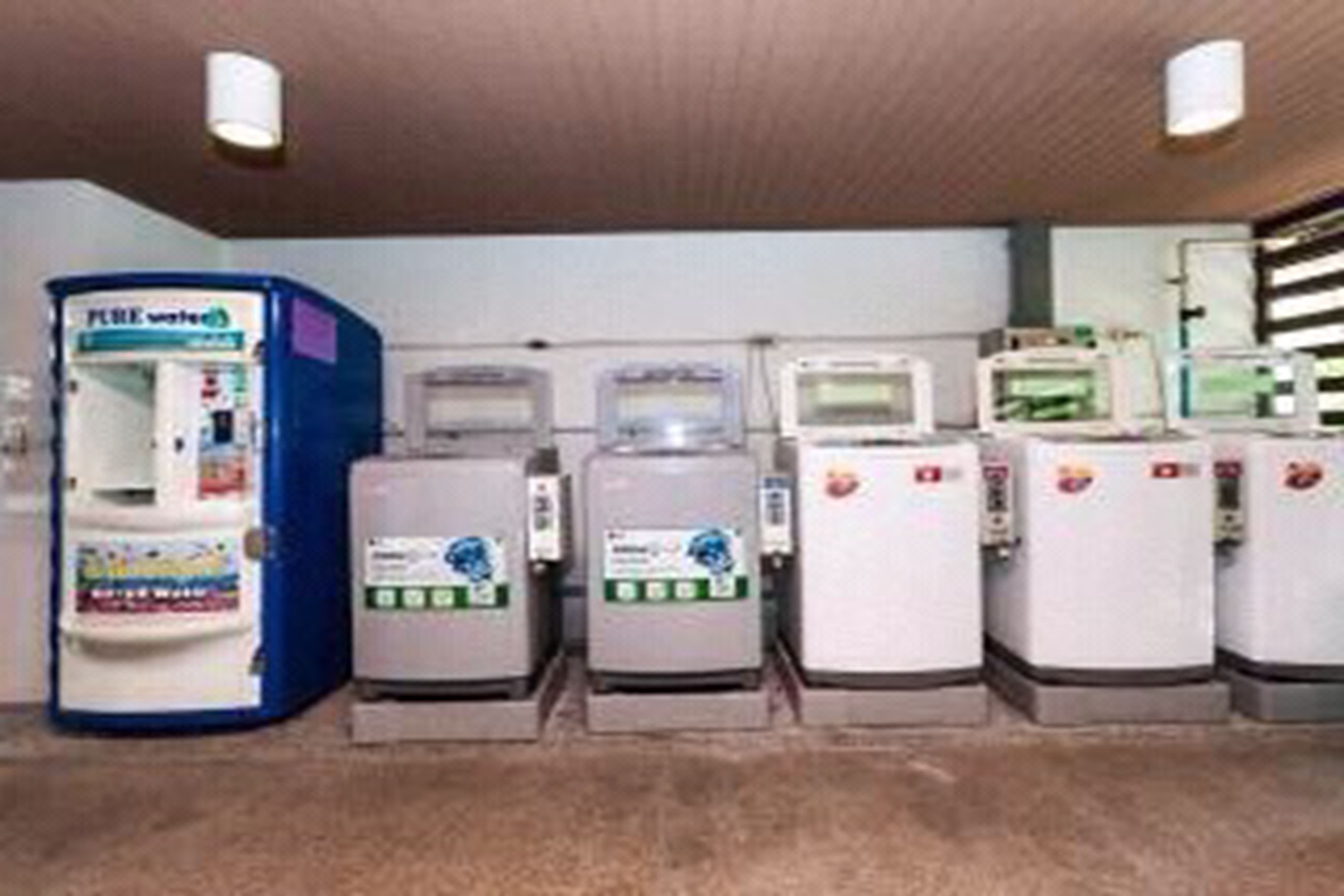 A row of self-service beverage dispensers in a public area.